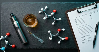 Vape device, molecular models, beaker, and clipboard on dark slate surface