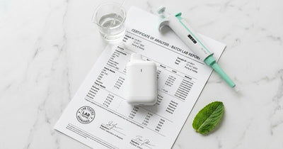White vape device on a certificate of analysis document with laboratory equipment — clean vaping concept